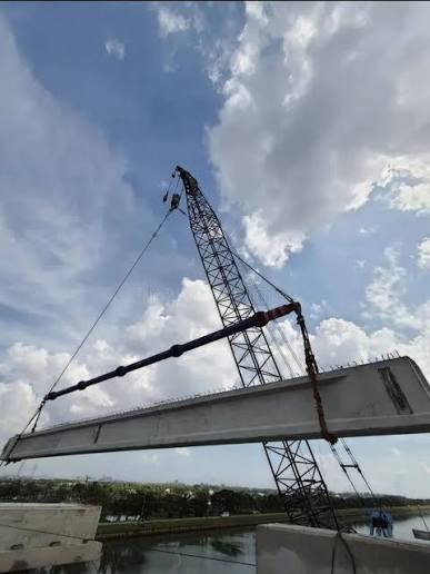 Ground-supported crawler crane lifting precast concrete bridge segments